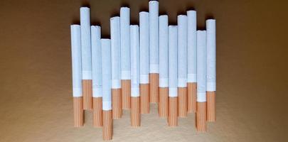 Image of several commercial cigarettes. pile of cigarettes on a gold background or concept of anti-smoking campaign, tobacco photo