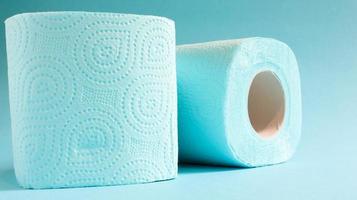 Blue roll of modern toilet paper on a blue background. A paper product on a cardboard sleeve, used for sanitary purposes from cellulose with cutouts for easy tearing. Embossed drawing photo