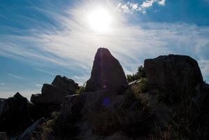 la piedra alinea la puesta de sol vertical, la piedra recta, el sol vespertino, el fondo solo de roca foto