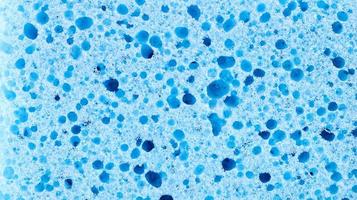 Background in the form of a porous structure in blue. Macro sponge. Close up blue sponge surface for textured background. copy space. photo
