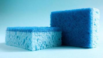 Two blue sponges used for washing and erasing dirt used by housewives in everyday life. They are made of porous material such as foam. Detergent retention, which allows you to spend it economically photo