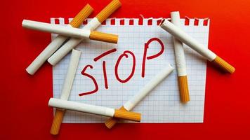 una pegatina que dice detener está en un paquete de cigarrillos. día mundial sin tabaco. dejar de fumar. pelear con cigarrillos foto