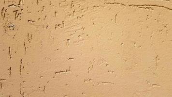 Old gold plaster wall texture yellow background. Textured textured wall plaster. Embossed wall decoration. Stucco walls. Embossed wall decoration. Decorative plaster is painted yellow. photo