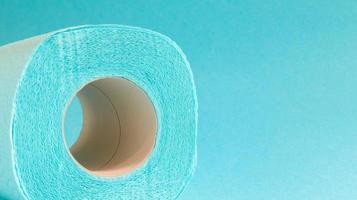 Blue roll of modern toilet paper on a blue background. A paper product on a cardboard sleeve, used for sanitary purposes from cellulose with cutouts for easy tearing. Embossed drawing. copy space. photo