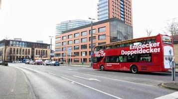 Dusseldorf, Germany - February 20, 2020. City tours by bus in Europe. Red double-decker sightseeing bus on a city street. Visit all the best attractions. photo