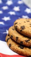 galletas patrióticas. tres galletas de chispas de chocolate tradicionales redondeadas en el fondo de la bandera de los estados unidos de américa. deliciosos pasteles dulces, postre. el regalo favorito de América. foto