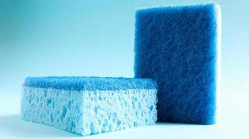 Two blue sponges used for washing and erasing dirt used by housewives in everyday life. They are made of porous material such as foam. Detergent retention, which allows you to spend it economically photo