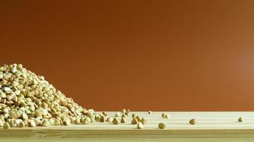 Green buckwheat seeds on a wooden background. Great food. healthy groats. Organic raw non-fried vegetarian food. The concept of a healthy, balanced and dietary diet. Copy space. photo