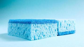 Two blue sponges used for washing and erasing dirt used by housewives in everyday life. They are made of porous material such as foam. Detergent retention, which allows you to spend it economically photo