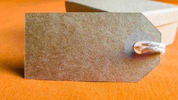 Cardboard boxes with a tag. Brown packing box with blank label and copy space on red backdrop photo