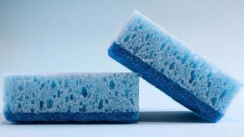 Two blue sponges used for washing and erasing dirt used by housewives in everyday life. They are made of porous material such as foam. Detergent retention, which allows you to spend it economically photo
