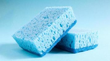 Two blue sponges used for washing and erasing dirt used by housewives in everyday life. They are made of porous material such as foam. Detergent retention, which allows you to spend it economically photo