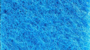 Background in the form of a porous structure in blue. Macro sponge. Close up blue sponge surface for textured background. copy space. photo