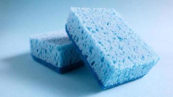 Two blue sponges used for washing and erasing dirt used by housewives in everyday life. They are made of porous material such as foam. Detergent retention, which allows you to spend it economically photo