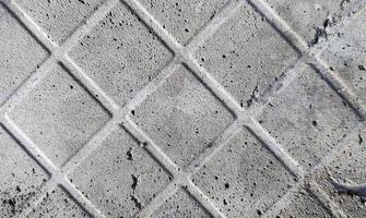 fondo de un viejo suelo de hormigón gris oscuro y rayado con restos de baldosas. textura de hormigón, rastro de azulejos caídos de color gris oscuro, estructura de malla, piezas de hormigón foto