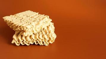 Raw dried instant noodles on a brown background. pasta, for the preparation of which it is enough to pour boiling water and wait a few minutes. Copy space. Vermicelli, spaghetti. photo
