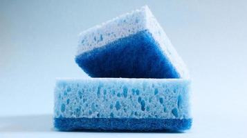 Two blue sponges used for washing and erasing dirt used by housewives in everyday life. They are made of porous material such as foam. Detergent retention, which allows you to spend it economically photo