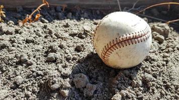 Closeup White leather textured baseball ball with red seams. Ball Outside Stadium Home Run Concept photo