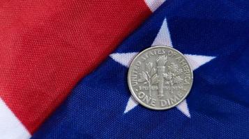A 1 cent American dollar coin lies on the American flag. The currency is one cent over the flag of the United States. photo