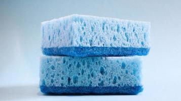 Two blue sponges used for washing and erasing dirt used by housewives in everyday life. They are made of porous material such as foam. Detergent retention, which allows you to spend it economically photo