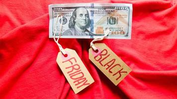 Label paper with the text black friday on a red background with american dollars. Shopping, sale concept. Close-up, copy space photo