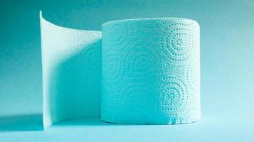 Blue roll of modern toilet paper on a blue background. A paper product on a cardboard sleeve, used for sanitary purposes from cellulose with cutouts for easy tearing. Embossed drawing photo