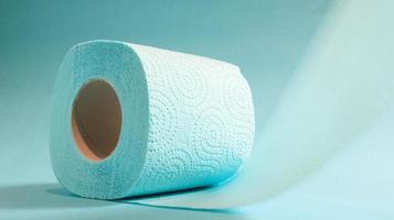 Blue roll of modern toilet paper on a blue background. A paper product on a cardboard sleeve, used for sanitary purposes from cellulose with cutouts for easy tearing. Embossed drawing photo