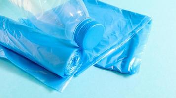 One roll of plastic trash bags in blue on a blue background. Bags that are designed to accommodate garbage in them and used at home and placed in various garbage containers. Copy space photo