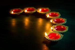 Happy Diwali - Clay Diya lamps lit during Diwali celebration. Greetings Card Design of Indian Hindu Light Festival called Diwali photo