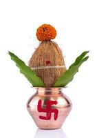 kalash de cobre con hoja de coco y mango con decoración floral sobre fondo blanco. esencial en puja hindú. foto