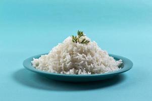Cooked plain white basmati rice with corriander in a blue plate on blue background photo