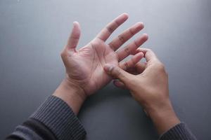 man suffering pain in hand close up photo