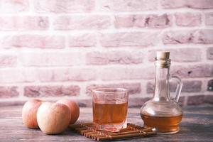 apple vinegar in glass bottle with fresh green apple on table photo