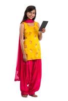 Young Indian girl using a mobile phone or smartphone isolated on a white background photo