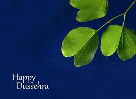 Indian Festival Dussehra, showing golden leaf on blue background. Greeting card. photo