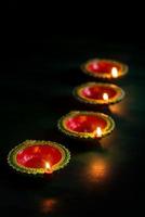 Happy Diwali - Clay Diya lamps lit during Diwali celebration. Greetings Card Design of Indian Hindu Light Festival called Diwali photo