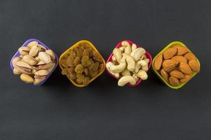 Healthy Mix Dry Fruits and Nuts on dark background. Almonds, Pistachio, Cashews, Raisins photo