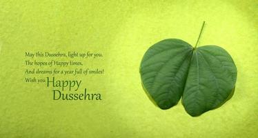 Indian Festival Dussehra, showing golden leaf and flowers on green background. Greeting card. photo
