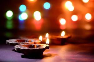 Clay diya lamps lit during Diwali Celebration. Greetings Card Design Indian Hindu Light Festival called Diwali photo