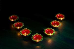 Happy Diwali - Clay Diya lamps lit during Diwali celebration. Greetings Card Design of Indian Hindu Light Festival called Diwali photo