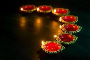 Happy Diwali - Clay Diya lamps lit during Diwali celebration. Greetings Card Design of Indian Hindu Light Festival called Diwali photo