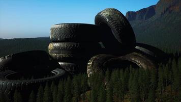 concept of environmental pollution with big old tires in mountain forest video