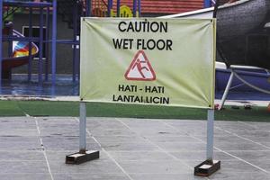 wet floor sign on the swimming pool photo