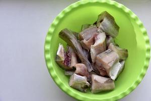 Freshly cleaned pollock fish in a green plate photo
