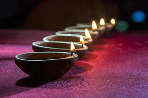 Clay diya lamps lit during Diwali Celebration. Greetings Card Design Indian Hindu Light Festival called Diwali photo