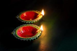 Happy Diwali - Clay Diya lamps lit during Diwali celebration. Greetings Card Design of Indian Hindu Light Festival called Diwali photo
