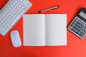 Notebook with pen are on top of office desk table with computer tools and supplies. Top view with copy space, flat lay.  Finance and banking advertising photo