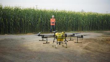 Male engineer controlling drone spraying fertilizer and pesticide over farmland,High technology innovations and smart farming photo