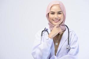 Female muslim doctor with hijab over white background studio. photo