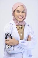 Female muslim doctor with hijab over white background studio. photo